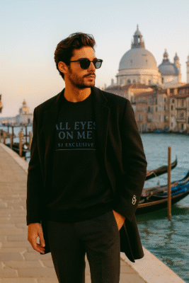 Sweat-shirt noir SJ EXCLUSIVE “ALL EYES ON ME” porté par un mannequin chic à Venise, look lifestyle premium, col rond heavyweight